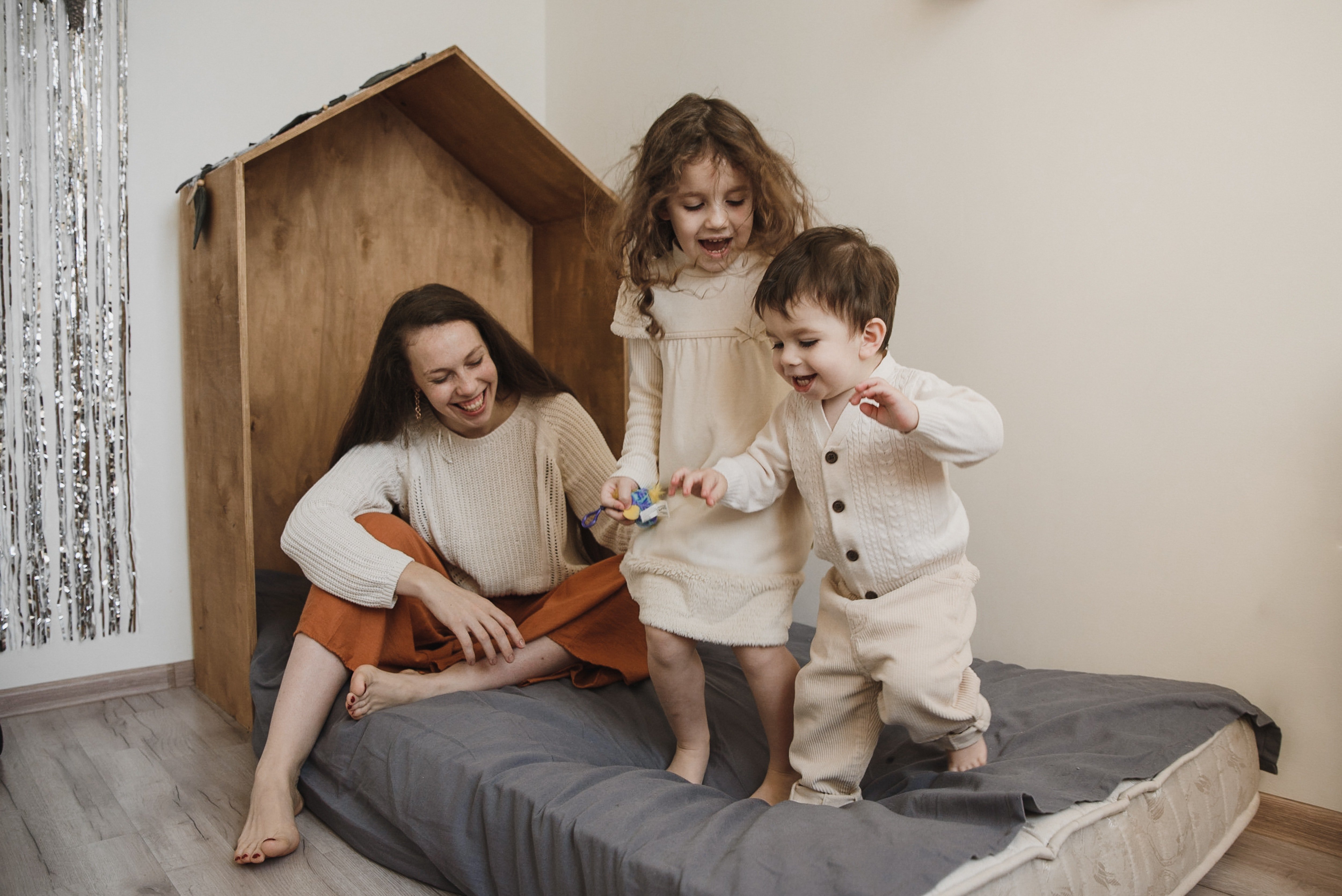 bebek odasında çocuklarıyla keyifli vakit geçiren anne görseli